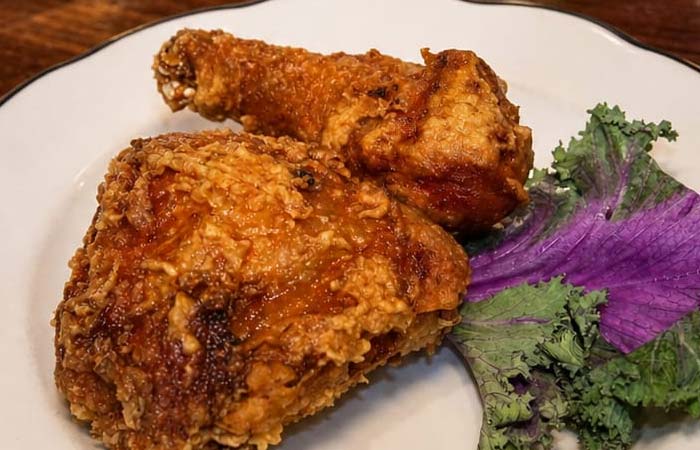 Enjoy two crispy fried chicken pieces at Libertys Bar, served with kale garnish in Red Wing MN.