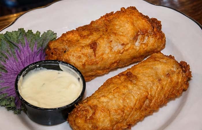 Enjoy these golden-brown egg rolls at our downtown bar, served with sauce and a fresh garnish.