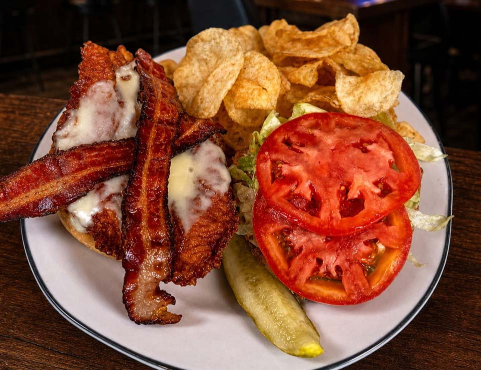 Open-faced BLT sandwich served downtown with chips, pickle spear, and sliced Minnesota tomato.